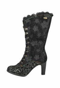 Bottine noire avec un superposé de dentelle florale, bord supérieur festonné et motifs floraux en relief. Dotée d'un talon haut et de détails de couture décoratifs.