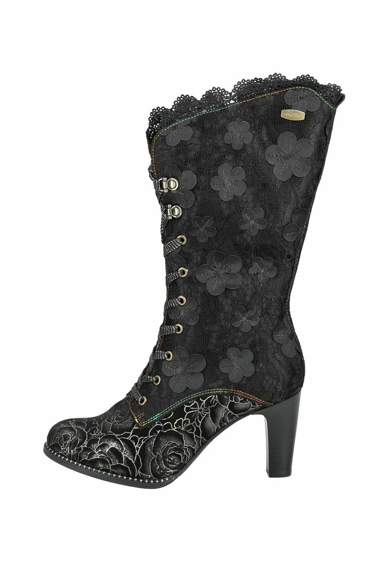 Bottine noire avec un superposé de dentelle florale, bord supérieur festonné et motifs floraux en relief. Dotée d'un talon haut et de détails de couture décoratifs.