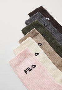 Septiņi pāri ribotas zeķes krāsās: rozā, krēmkrāsā, bēša, olīvu, pelēka, tumši zaļa un brūna. Katrai ir melns Fila logos.