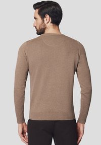 Brązowy sweter prążkowany wykonany z dzianiny, z długimi rękawami i okrągłym dekoltem. Teksturowane wykończenie z dopasowanym pasem i mankietami.