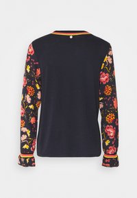 T-shirt à manches longues avec un corps bleu marine foncé et des manches à motif floral dans des teintes de rose, jaune et rouge, avec une bordure contrastée aux poignets.