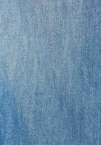 Hellblauer Denim-Stoff mit leicht strukturierten Oberflächen, der subtile Farb- und Webmusterabweichungen aufweist.