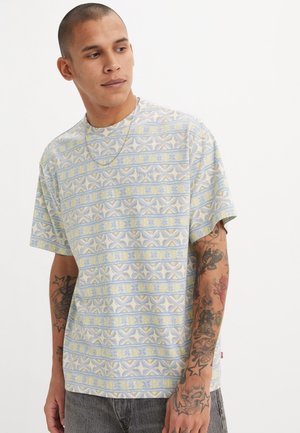 Korte mouwen, ronde hals t-shirt in lichtblauw met geometrische patronen in geel en room. Zachte stof met een ontspannen pasvorm.