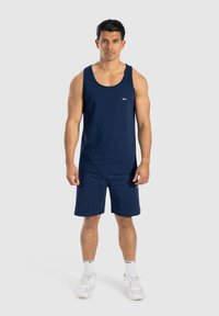 Completo di canotta e pantaloni corti in cotone di colore blu navy. La canotta presenta un collo rotondo, e i pantaloni corti hanno una vita elastica.