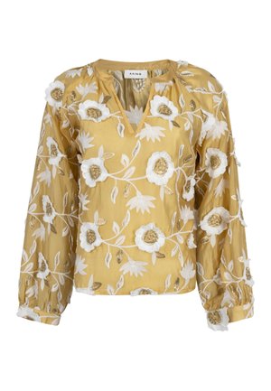 Gele blouse met witte en gouden bloemrijke borduursels, lange opgeblazen mouwen en een ronde halslijn met een V-vormige split.