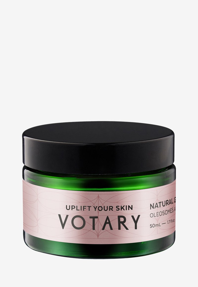 Grünes Glasgefäß mit schwarzem Deckel, das Votary Hautpflegecreme enthält, beschriftet mit "Uplift Your Skin", 50 ml Größe, natürliche Glow-Formel.