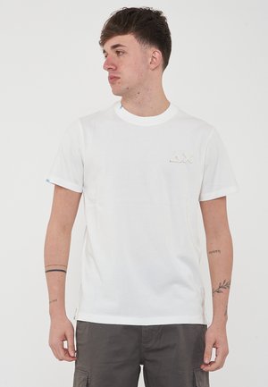 T-shirt in cotone bianco con collo rotondo, maniche corte e un piccolo logo ricamato sul petto. Tessuto morbido, vestibilità rilassata.