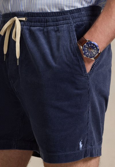 Σορτς από βελούδο κοτλέ σε ναυτικό μπλε με ελαστική μέση και εκρού κορδόνι. Διαθέτει πλαϊνές τσέπες και μικρό κεντημένο λογότυπο στο κάτω μέρος.