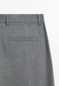 Back of light gray dress pants with belt loops and a single welt pocket on a plain white background.