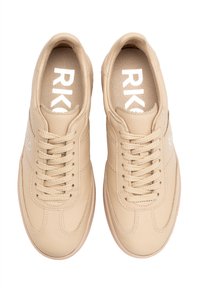 Beežid nahksneakerid tekstuuriga viimistlusega, ümarate varvastega ja lamedate paeltega. Siseosa peal on suurel valgel kirjas "RK".