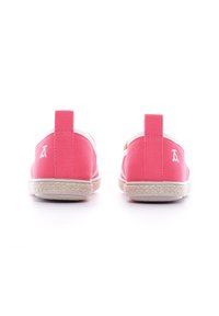 Scarpe slip-on in tela rosa con suola in gomma bianca, dotate di un piccolo logo sul tallone e suola testurizzata per una migliore aderenza.