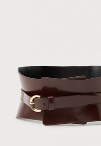 Barna, fényes bőrből készült öv, széles kialakítással, aranyszínű, kör alakú csattal és sima felülettel. Elegáns varrási részletek is szerepelnek rajta.