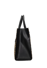 Borsa tote in pelle nera vista di lato con due manici arrotondati e lati in tessuto stampato su sfondo bianco.