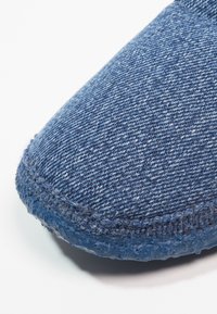 Denim instapper met een bovenwerk van blauwe stof, geweven textuur, ronde neus en rubberen zool met een licht glanzende afwerking.