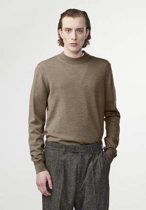 Bruine lange mouwen trui met een ronde hals, gemaakt van zacht materiaal. Gecombineerd met grijze geplooide broek met een textuurfinish.
