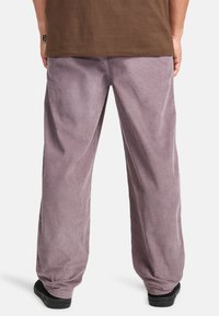 Purple corduroy pants with a relaxed fit, featuring vertical ribbing, visible side seams, and a plain waistband.