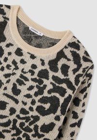 Maglione a maglia con base beige e macchie di leopardo nere. Presenta un colletto girocollo a coste e un tessuto testurizzato. Etichetta visibile sul colletto.