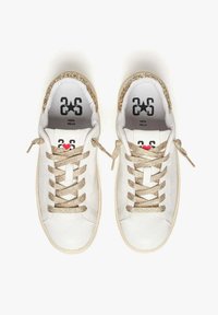 Sneaker in pelle bianca con dettagli dorati luccicanti, lacci piatti e un cuore rosso. La scritta sulla linguetta riporta "25" e "Vera Pelle."