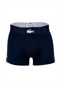 Calzón boxer azul marino con un ajuste ceñido, hecho de algodón suave. Presenta una cinturilla en contraste con el logo de Lacoste en blanco y un diseño de cocodrilo.