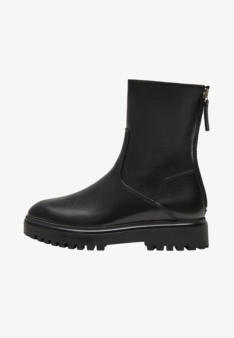 Bottines noires en cuir lisse, dotées d'une fermeture zippée, d'un embout arrondi et d'une semelle à bande de roulement robuste pour une meilleure traction.