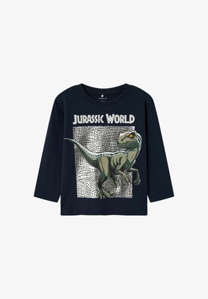Marineblauwe t-shirt met lange mouwen, voorzien van een grafisch ontwerp van een dinosaurus met gele ogen en schubben tegen een gestructureerde zilveren achtergrond.