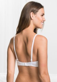 Reggiseno bianco con spalline regolabili, tessuto liscio e chiusura con gancio e occhiello sulla schiena. Design semplice, senza motivi o accenti prominenti.