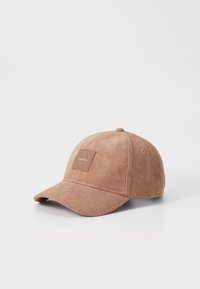 Pruunist kammkarvasest materjalist pesapallimüts, millel on kõver visor ja esiküljel ruudukujuline nahktempel, millel on kiri "Calvin Klein".