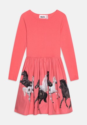 Robe longue à manches longues corail avec un haut ajusté et une jupe plissée ornée de chevaux au galop en noir, blanc et gris sur un fond corail.