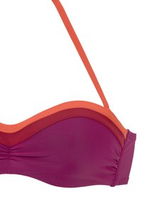 Bikini viršus su purpuriniu apatinio sluoksnio ir oranžinėmis dirželių. Pasižymi lygiu, tampriu audiniu su surinktu išsidėstymu prie apačios.