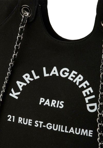 Черна чанта Karl Lagerfeld с бял текст "KARL LAGERFELD PARIS 21 RUE ST-GUILLAUME" и детайл със сребриста верижка.