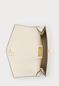 Κρεμ βλέκον τσάντα χεριού με δομημένο σχέδιο, χρυσά αξεσουάρ και λεπτομέρεια λογότυπου. Διαθέτει έναν μόνο χώρο και κλείσιμο με κούμπωμα.