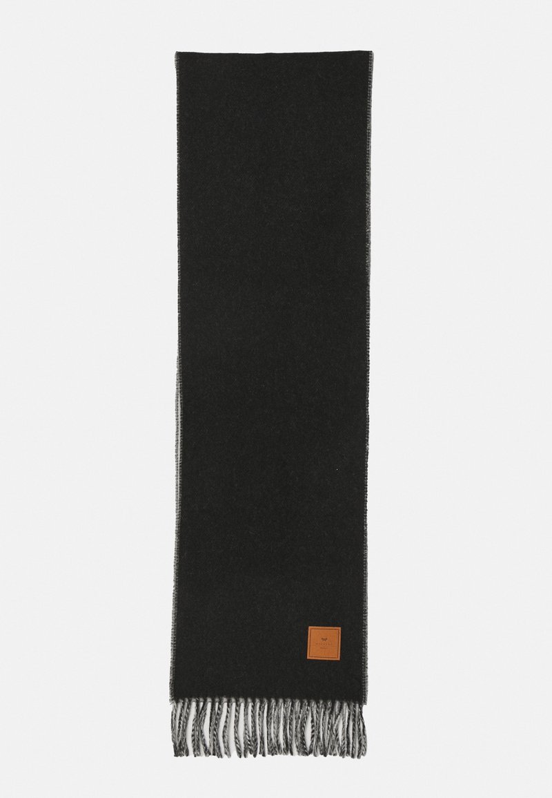 Écharpe en laine noire avec des franges grises et une petite pièce en cuir marron près d'une extrémité sur un fond clair.