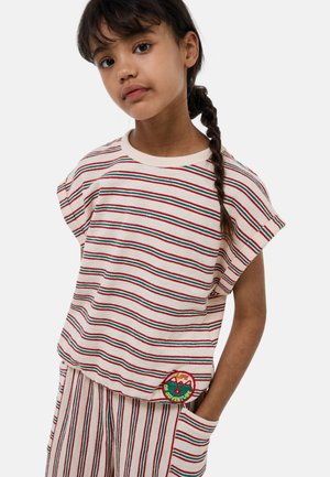 T-shirt en coton rayé de couleur crème, avec des lignes rouges et vertes, col rond et manches courtes. Comprend un patch circulaire avec "La Vie d'Aventure."