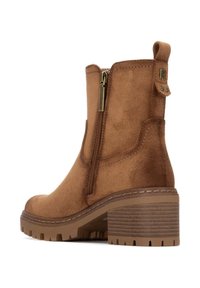 Stivale alla caviglia in suede marrone con zip laterale, caratterizzato da un tacco medio texture e una suola in gomma con un motivo scanalato per una migliore aderenza.