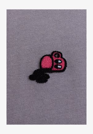 Borduurwerk van een cartoonachtige roze camera ontwerp met zwarte accenten op een gestructureerde, gematigde lavendelkleurige stof.