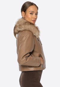 Bruine leren cropped jack met een met bont gevoerde kraag, voorzien van ritszakken en op maat gemaakte naden voor een slanke uitstraling.