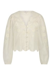 Crème kleurige blouse met pofmouwen, gegolfde halslijn, geborduurde bloemen- en hartmotieven, en vijf kleine knopen aan de voorkant.