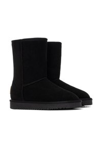 Botas de tobillo de ante negro con puntera redondeada y costuras en tono. Cuenta con una suela de goma plana y un pequeño parche con el logo en el lateral.