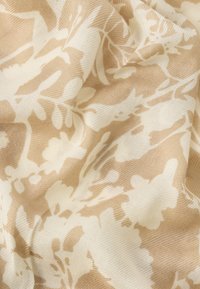 Béžová látka s bielym kvetinovým vzorom; ľahká, mierne textúrovaná a jemne splývavá s jemným leskom v rôznych kvetinových tvaroch.