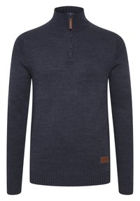 Pull en maille côtelée gris foncé avec un demi-zip et un col montant, présentant un petit patch en cuir de la marque près de l'ourlet.