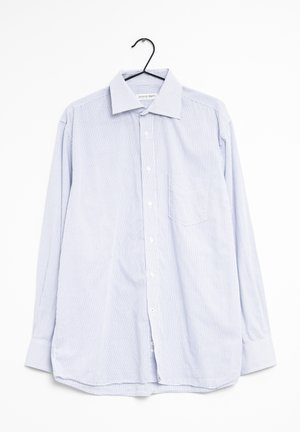 Camisa de manga larga a cuadros en azul claro y blanco colgada de una percha. Presenta un cierre de botones, cuello y un único bolsillo en el pecho. Textura de tela suave.