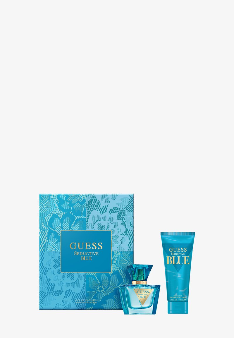 Guess Seductive Blue perfume gift set with blue floral-patterned box, perfume bottle with gold label, and matching body lotion tube.