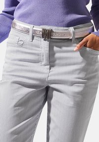 Gestreepte blauw-witte broek met een slim fit en een zilveren metallic riem met een reliëf gesp in de vorm van een letter, gecombineerd met een geribbelde paarse trui.