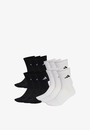 Eight pairs of Adidas crew socks, four black and four white, each with a small Adidas logo on the ankle.