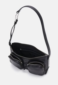 Sac en cuir noir avec bandoulière ajustable, doté de plusieurs poches zippées, de lignes épurées et d'une texture lisse. L'intérieur présente des compartiments d'organisation.