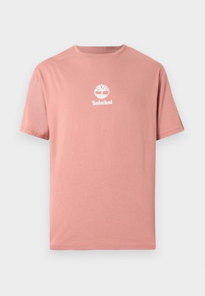 T-shirt en coton à manches courtes de couleur rose clair avec le logo arbre Timberland blanc et un texte centrés sur la poitrine.
