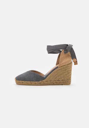 Grå lærred espadrille kilehæle med en vævet jute sål, åben bag og justerbar ankelbinding lavet af stof. Glat tekstur og spids tådesign.