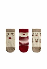 Tres pares de calcetines para niños: uno con la cara de un reno, otro con rayas rojas y blancas, y otro con patrones repetidos de renos. Colores beige y rojo.
