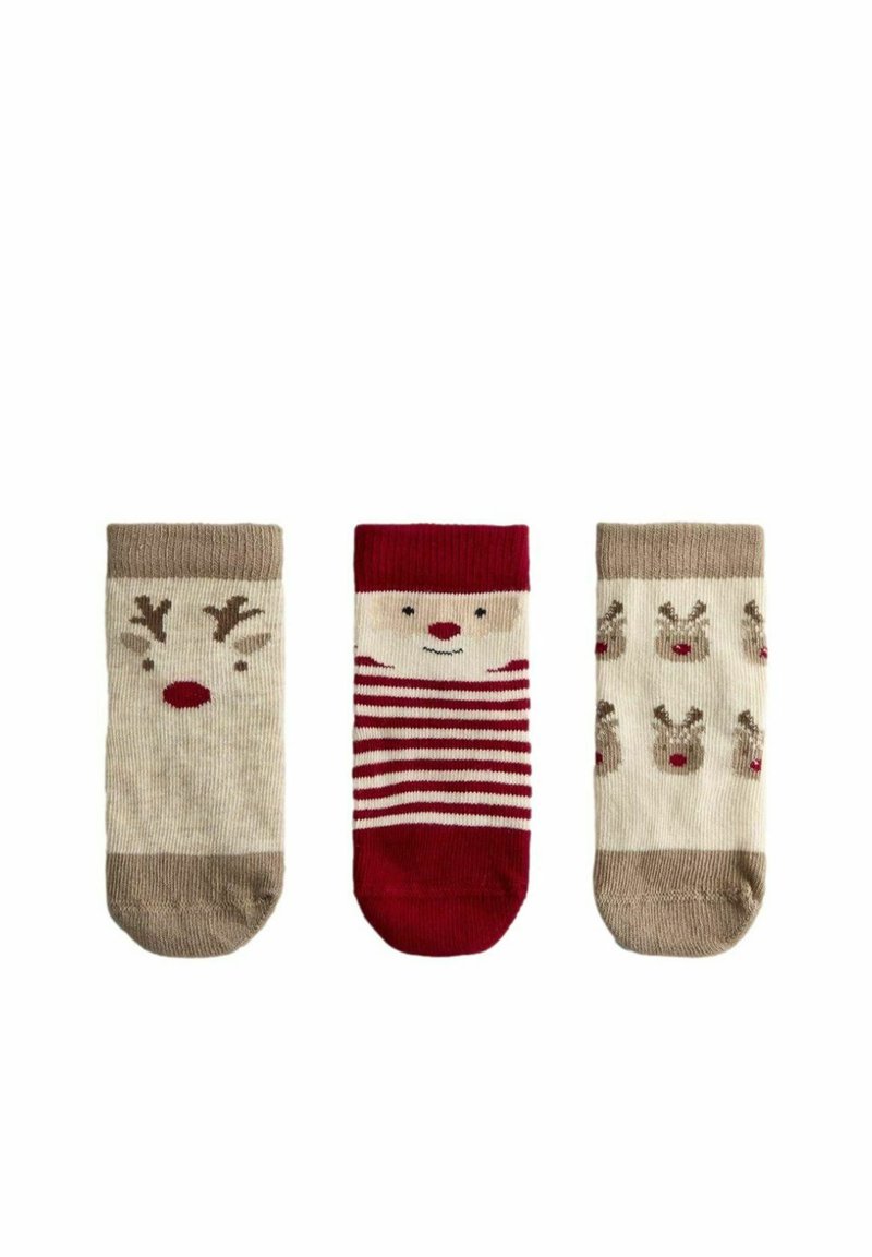 Tres pares de calcetines para niños: uno con la cara de un reno, otro con rayas rojas y blancas, y otro con patrones repetidos de renos. Colores beige y rojo.
