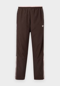 Καφέ αθλητικό παντελόνι με ελαστική μέση, με ροζ λεπτομέρειες και λευκές ρίγες στο πλάι. Κατασκευασμένο από λεπτό και ελαφρύ ύφασμα.